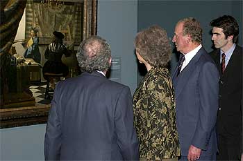 Los Reyes, junto al presidente del Patronato del Museo del Prado, Eduardo Serra (de espaldas), contemplan uno de los cuadros de la exposición 'Vermeer y el interior holandés', inaugurada en el Museo del Prado.