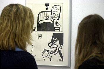 Dos visitantes contemplan una de las viñetas del humorista.