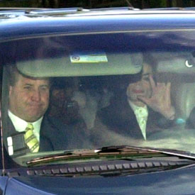 El cantante saluda tras salir de la comisaría camino del aeropuerto.