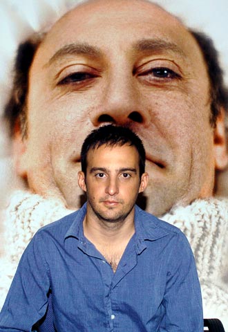 Alejandro Amenábar posa ante el cartel de  Mar adentro. 
