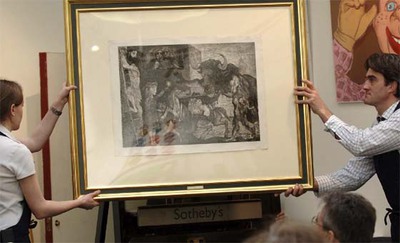 Dos trabajadores sujetan el grabado  La minotauromaquia  de Pablo Picasso, expuesto en la casa de subastas Sotheby's en Londres.