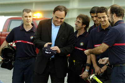 El director estadounidense Oliver Stone, posa junto a una dotación local de bomberos en San Sebastián momentos antes de presentar su película 'World Trade Center'.