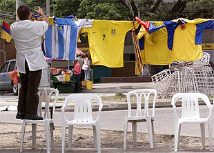   Argentina renuncia a jugar la Copa América   En la imagen, un comerciante de Medellín retira de su puesto la camiseta de la selección argentina. 
