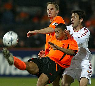 El defensa holandés Reiziger despeja el balón ante Raúl y su compañero De Boer.