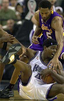 El jugado de los Kings, Chris Webber, abajo, lucha con Robert Horry, de los Lakers, la posesión del balón en el quinto partido de la final de la Conferencia Oeste.