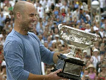 Agassi es regado con cava tras recibir el trofeo que le acredita como ganador en Australia.