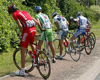 Un grupo de ciclistas aprovecha un momento tranquilo de la etapa para aliviar sus necesidades.