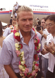 El jugador del Real Madrid, David Beckham, apodado  Becks  por los aficionados, es agasajado con una corona de flores durante la llegada del equipo blanco a la ciudad china de Kunming, punto de arranque de la gira asiática madridista.