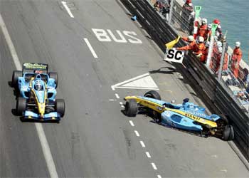 Trulli atraviesa el coche averiado de su compañero en Renault, Fernando Alonso.
