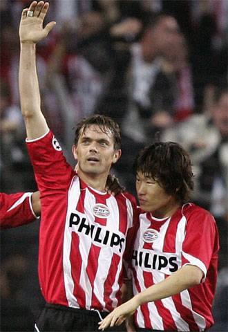 Cocu celebra con su compañero Park su primer tanto al Milan.