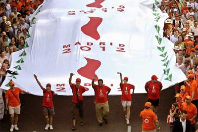 Miles de personas han desplegado la bandera olímpica, la más grande del mundo, en el centro de Madrid.