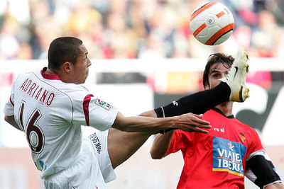 El jugador del Sevilla Adriano y el del Mallorca Pereyra durante el encuentro disputado hoy en el Sánchez Pizjuan.
