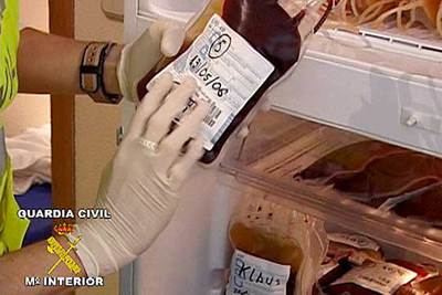 Un agente sostiene una bolsa de sangre congelada durante uno de los registros practicados en la operación 
