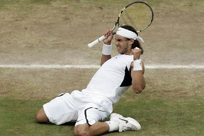 Nadal celebra su histórico triunfo en el césped de la pista central de Wimbledon.