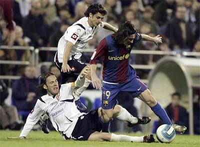 Messi lucha por el balón ante Aimar y Milito