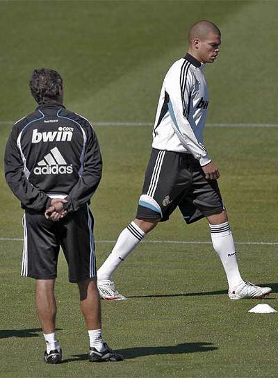 El técnico del Real Madrid, Juande Ramos, de espaldas mientras Pepe camina sobre el césped de Valdebebas.