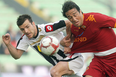 Lukovic, del Udinesem pelea por el balón con el delantero del Roma Toni