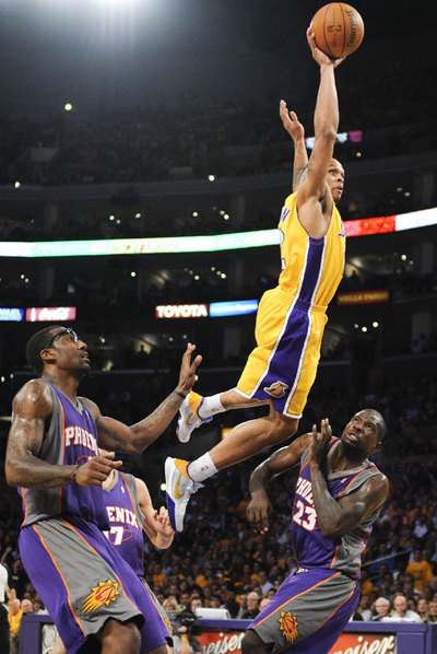 El jugador de los Lakers Sannon Brown a punto de encestar ante la mirada de dos de los jugadores del equipo de los Suns.