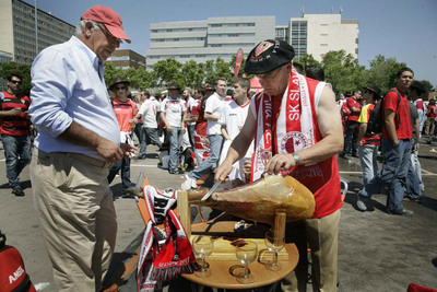 Cientos de sevillistas esperan el inicio del partido en un parque junto al Camp Nou de Barcelona.