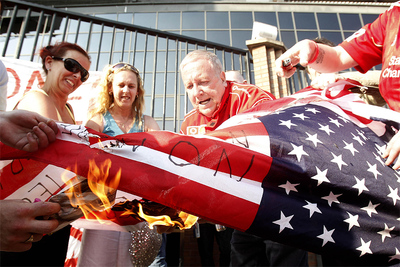 Aficionados del Liverpool queman una bandera estadounidense en los exteriores de Anfield Road en protesta por la marcha de Rafa Benítez.