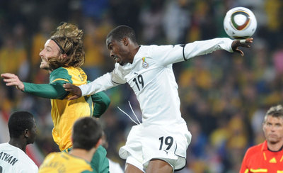El australiano Kennedy (izqda.) salta con el ghanés Addy en el partido del grupo D jugado en Rustenburgo