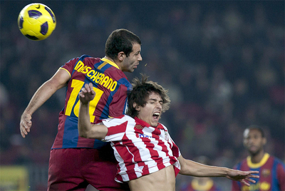 Mascherano y Javi Martínez disputan un balón aéreo.