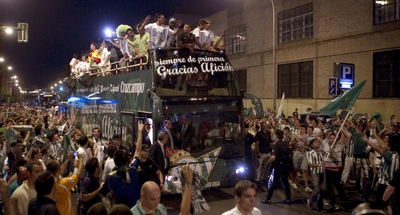 Los jugadores del Betis recorren las calles de Sevilla en un autobús descapotado tras conseguir el ascenso matemático.