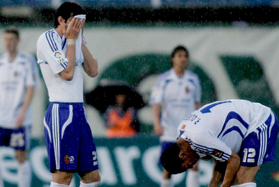 Los jugadores del Real Zaragoza, el argentino Diego Milito y el brasileño Ricardo Oliveira, se lamentan tras encajar un gol.