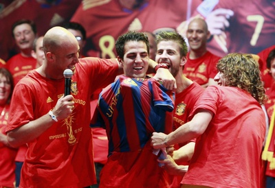 Puyol y Piqué colocan la camisetan del Barcelona a Cesc durante la celebración del Mundial.