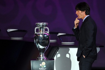 El seleccionador alemán, Löw, observa la Copa durante el sorteo.