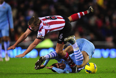 Cattermole, del Sunderland, pasa por encima de Dzeko.