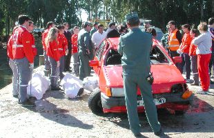 Guardias civiles y miembros de Cruz Roja observan el coche en el que viajaban los tres fallecidos.