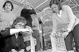 Cuatro mujeres preparan las bolas con las que se sortearán los pisos de protección de Vitoria.