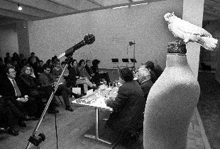 En primer plano el poema objeto  Parásito  (1991) durante la conferencia institucional de prensa.