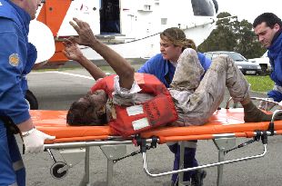 Uno de los tripulanes del Kristal es trasladado, desde el helicóptero que le rescató, en el aeropuerto de A Coruña.