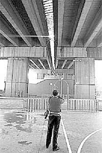 Un  ertzaina  fotografía el lugar por donde cayó el joven.