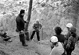 Un monitor da instrucciones a un joven que inicia el descenso en    rappel , ayer, en Cazorla.