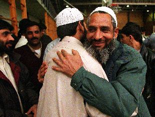 Dos inmigrantes musulmanes se saludan, ayer, en una fiesta religiosa.