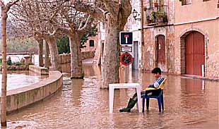 Un niño contempla la inundación provocada por el Ebro en la parte baja de Miravet.