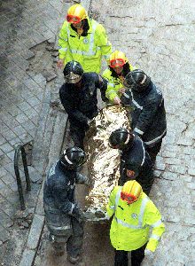 Varios obreros trasladaban ayer el cdáver de un obrero fallecido.