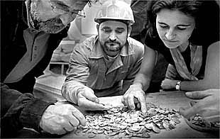 Martínez Villaescusa, con barba y casco, ayer junto a la arqueóloga del plan Riva y un obrero, con las monedas árabes.