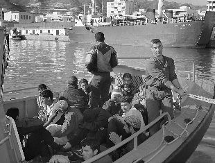Inmigrantes detenidos por miembros de Salvamento Marítimo cuando desembarcan en Motril.
