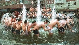 Los componentes del Quesos Entrepinares, de Valladolid, celebran su segundo título en la Liga de rugby con el baño en la fuente de la plaza de Madrid vallisoletana.
