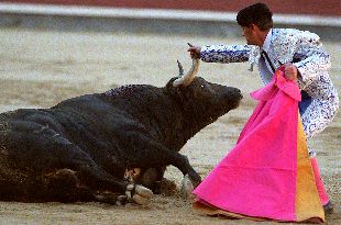Un peón intenta levantar al primer toro, inválido como toda la corrida.