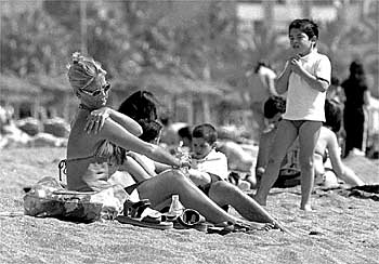 Una mujer y su hijo toman el sol en la céntrica playa de La Malagueta.