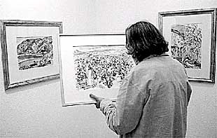 Un hombre observa una de las acuarelas de Menchu Gal expuestas en Bilbao.