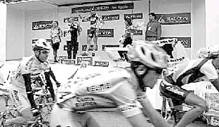 Varios rezagados entran en la meta de Mungia mientras Zanini recoge el trofeo tras ganar la etapa.