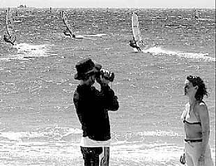 Dos turistas toman imágenes de recuerdo de una de las regatas de  Toro andaluz. 