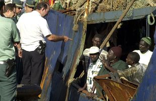 Guardias civiles hablan con los inmigrantes que llegaron en el  Ashva  el miércoles pasado a Tenerife.