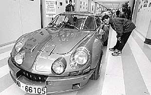 Un chaval obseva un deportivo en el palacio Europa de Vitoria.